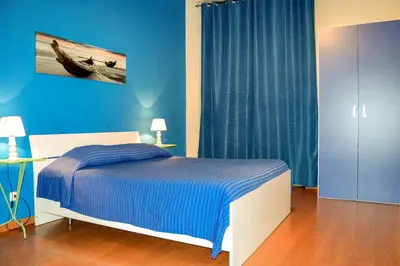 a bedroom with a bed and a blue wall at Cheap in Center in Palermo