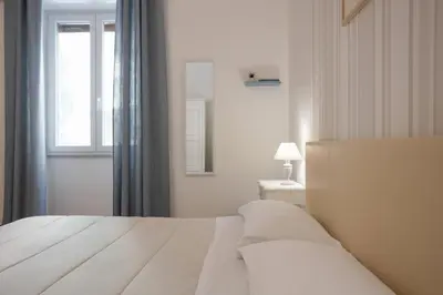 a white bedroom with a bed and a window at B&B Palermo Bella Rooms and Suites in Palermo