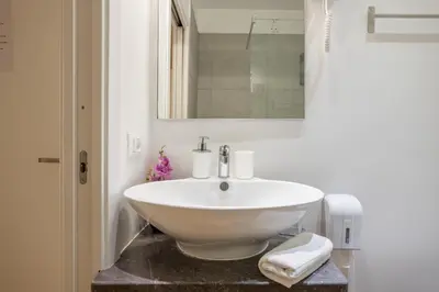 a bathroom with a white sink and a mirror at B&B Palermo Bella Rooms and Suites in Palermo