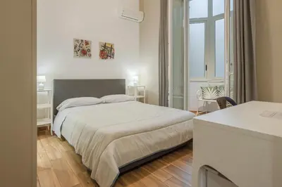 a white bedroom with a bed and a window at B&B Palermo Bella Rooms and Suites in Palermo