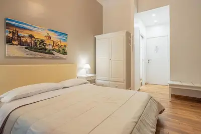 a bedroom with a large bed and a painting on the wall at B&B Palermo Bella Rooms and Suites in Palermo