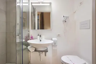 a white bathroom with a sink and a shower at B&B Palermo Bella Rooms and Suites in Palermo