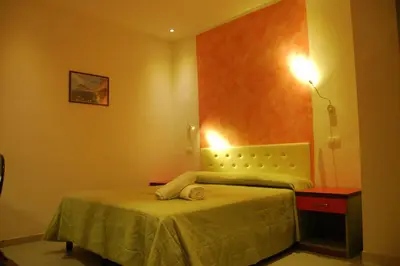 a small bedroom with a bed and a lamp at Bellevue del Golfo Hotel & Spa in Sferracavallo