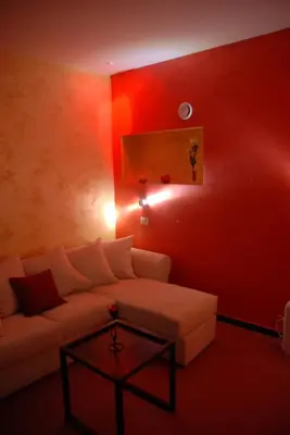 a living room with a couch and a red wall at Bellevue del Golfo Hotel & Spa in Sferracavallo