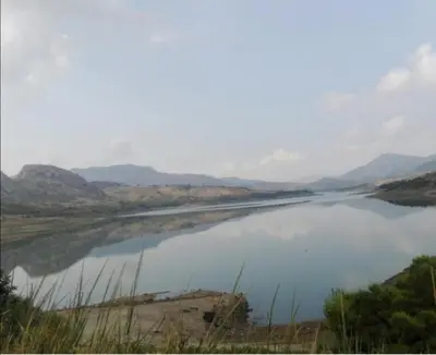 a large body of water with mountains in the background at L'Opuntia sul lago in Caccamo