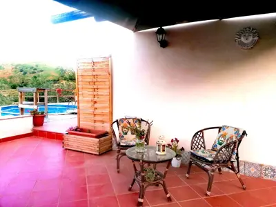 a patio with a table and chairs and a balcony at L'Opuntia sul lago in Caccamo