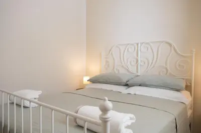 a white bed with a white headboard in a bedroom at Isabel House in Isola delle Femmine