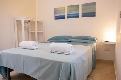 a bed with two towels sitting on top of it at Isabel House in Isola delle Femmine