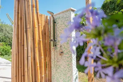 a fence with wooden posts and purple flowers at Isabel House in Isola delle Femmine