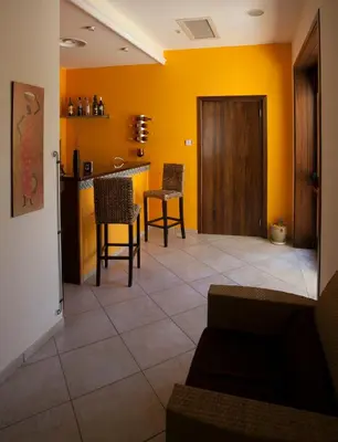 a living room with yellow walls and a table and chairs at Zingaro Hotel in San Vito lo Capo