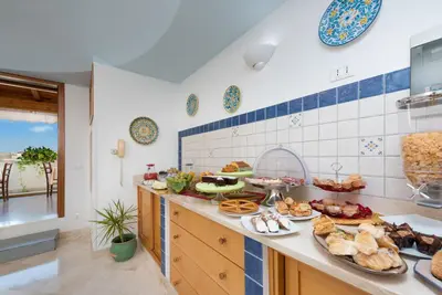 a kitchen with many plates of food on a counter at Hotel Halimeda in San Vito lo Capo