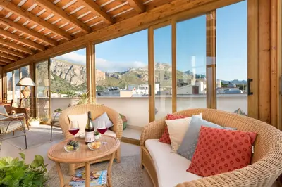 a living room with two chairs and a table with wine glasses at Hotel Halimeda in San Vito lo Capo
