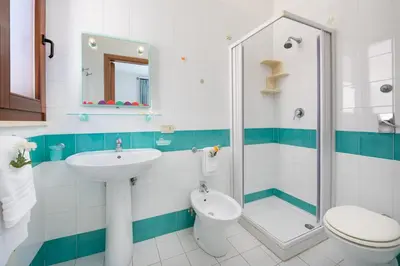 a bathroom with a sink and a toilet and a shower at Hotel Halimeda in San Vito lo Capo