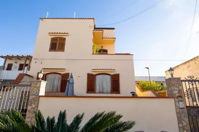 a white house with a fence at Casa Cavour sul Mare in San Vito lo Capo