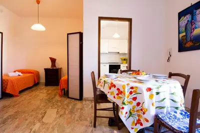 a dining room with a table with a bowl of fruit on it at Casa Cavour sul Mare in San Vito lo Capo