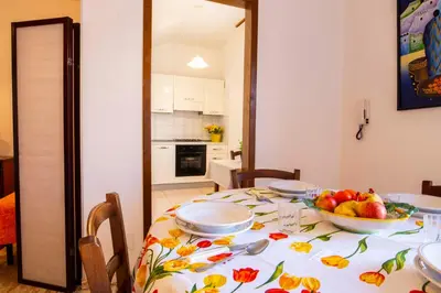 a dining room table with a bowl of fruit on it at Casa Cavour sul Mare in San Vito lo Capo