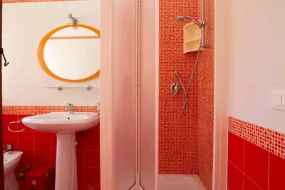 a red bathroom with a sink and a shower at Casa Cavour sul Mare in San Vito lo Capo