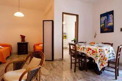 a dining room with a table and chairs and a bedroom at Casa Cavour sul Mare in San Vito lo Capo