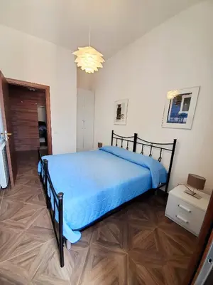 a bedroom with a large bed with a blue bedspread at Palazzo del Golfo in Castellammare del Golfo