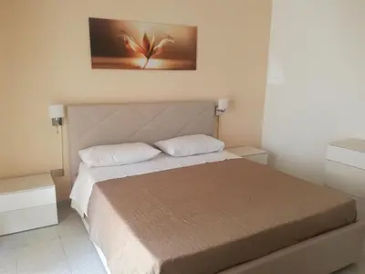 a bedroom with a bed and a painting on the wall at Giusy's Place 2.0 in Campofelice di Roccella