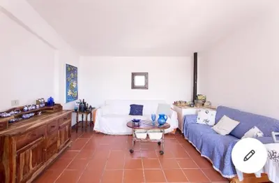 a living room with a blue couch and a table at la casa al mare in Trappeto