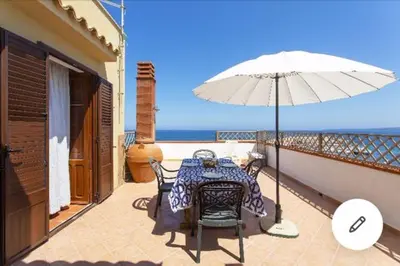 a table and umbrella on the balcony of a house at la casa al mare in Trappeto