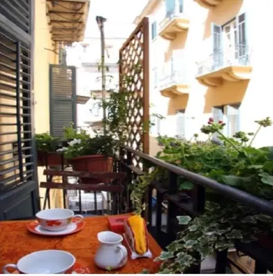 a table with a cup of coffee on a balcony at Baru's House in Palermo