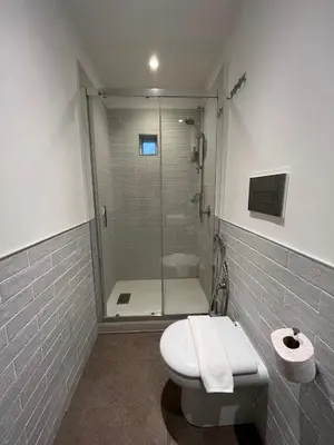 a bathroom with a shower with a toilet and a glass shower stall at Baru's House in Palermo