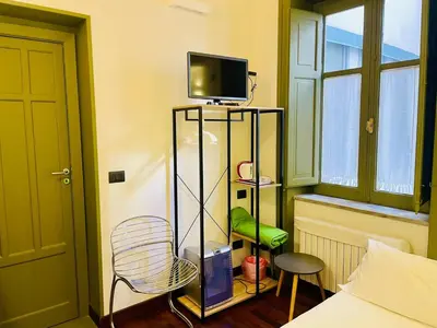 a room with a tv and a chair in a room at Baru's House in Palermo