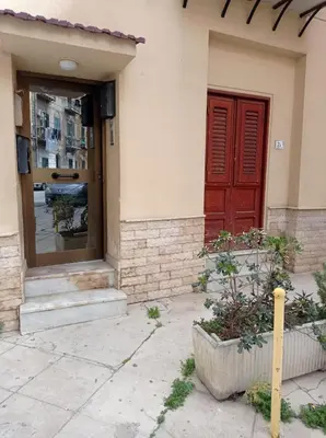 a building with a red door and a window at Appartamento di Giò in Palermo