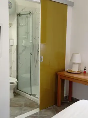 a bathroom with a shower with a toilet and a table at Appartamento di Giò in Palermo