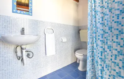 a blue tiled bathroom with a sink and a toilet at Villa Mucera in Ficarazzi