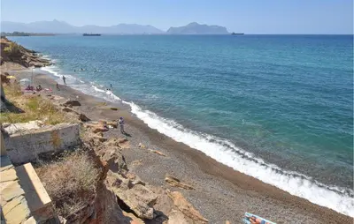 a group of people on a beach near the water at Villa Mucera in Ficarazzi