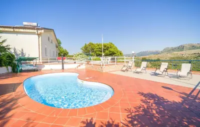 a swimming pool on a brick patio with chairs at 5 Bedroom Nice Home In Monreale in Monreale