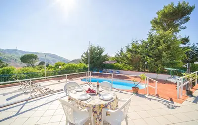 a patio with a table and chairs next to a pool at 5 Bedroom Nice Home In Monreale in Monreale