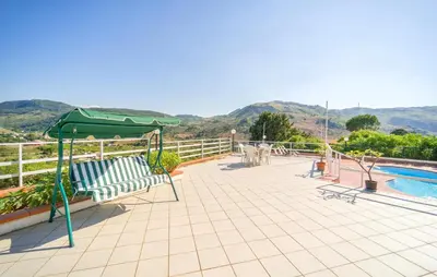 a patio with a green umbrella and a pool at 5 Bedroom Nice Home In Monreale in Monreale