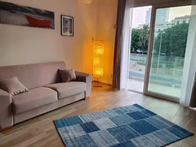 a living room with a couch and a large sliding glass door at Calalula Apartment Palermo in Palermo