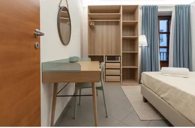 a bedroom with a desk and a bed and a mirror at H Urban in Palermo