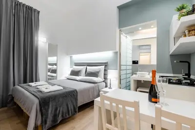 a small bedroom with a bed and a kitchen at Residenze Chamur Via Giuseppe Sciuti in Palermo
