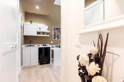 a kitchen with white cabinets and a black sink at Residenze Chamur Via Giuseppe Sciuti in Palermo
