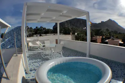 a bath tub on a balcony with a table and chairs at La casa di fronte la spiaggia di San Vito lo capo in San Vito lo Capo