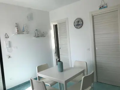 a white dining room with a white table and chairs at La casa di fronte la spiaggia di San Vito lo capo in San Vito lo Capo
