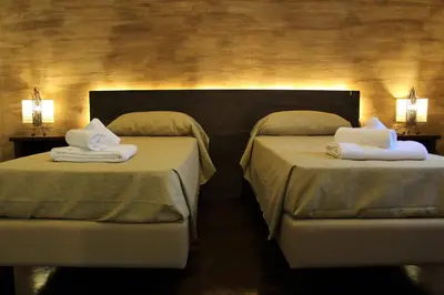 a hotel room with two beds with towels on them at B&B Atlante in Palermo