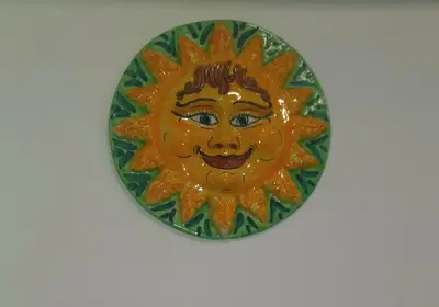 a plate with a smiling sun on a wall at Il Sole della Guilla in Palermo