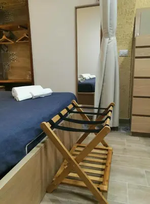 a wooden chair sitting on a bed in a room at Il Sole della Guilla in Palermo