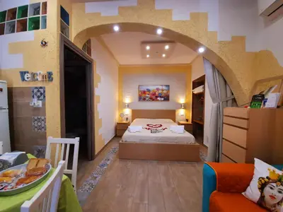 a bedroom with a bed and a couch in a room at Il Sole della Guilla in Palermo