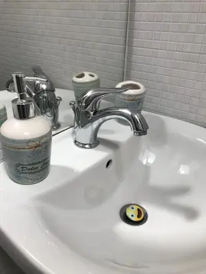 a bathroom sink with a faucet and two cups on it at Casa Nicolina in Palermo