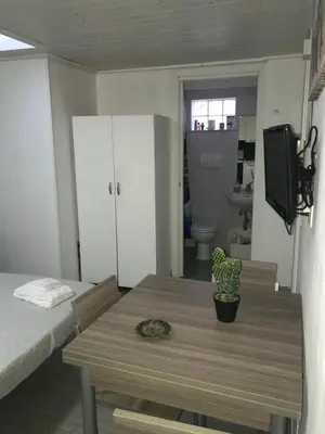 a room with a table and a bed and a tv at Casa Nicolina in Palermo