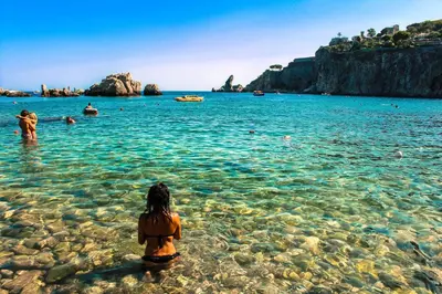 a woman sitting in the water at a beach at Casa Nicolina in Palermo