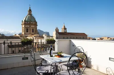a table and chairs on a balcony with a view at Sopra i tetti di Ballarò in Palermo